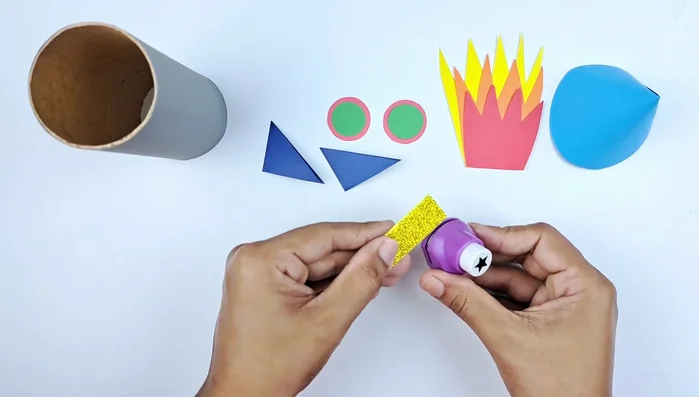 Cut out small sparkly stars (or other shapes) from sparkly paper and glue them to the rocket body.