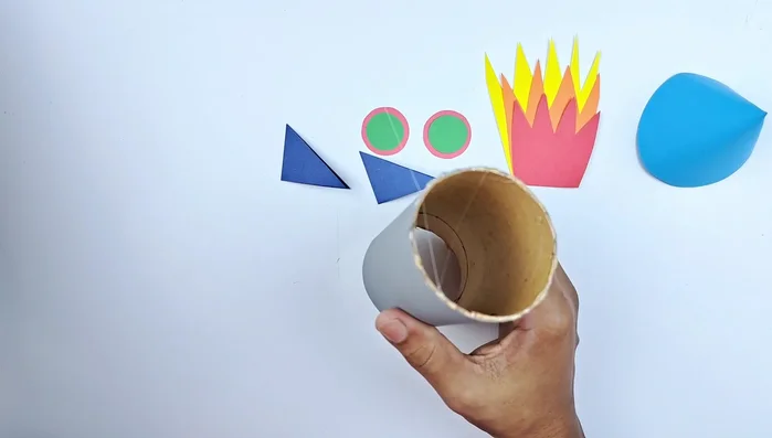 Glue the nose cone to the top of the toilet paper roll.