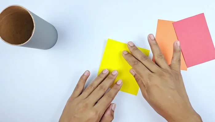 Draw and cut out flame shapes from yellow, orange, and red paper.