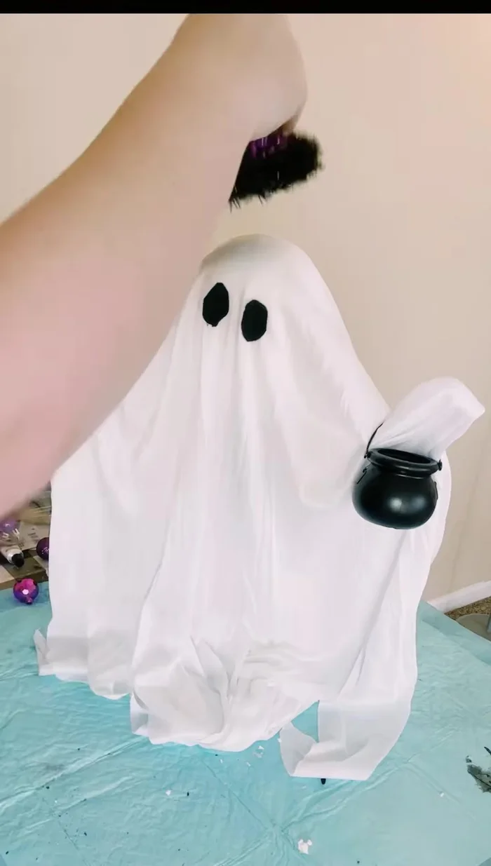 Fill the cauldron with small purple ornaments.