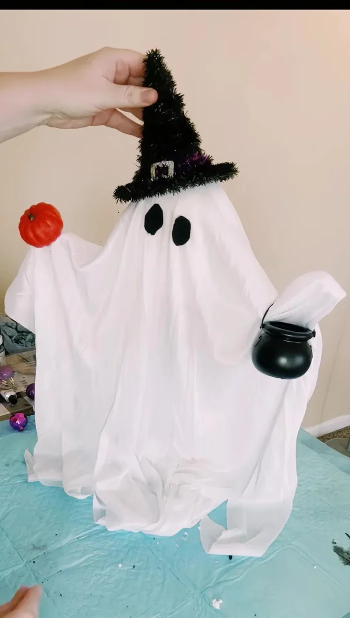 Fill the cauldron with small purple ornaments.