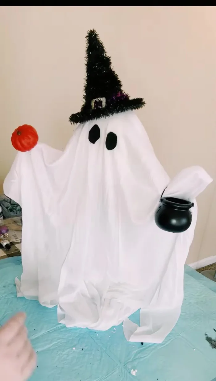 Fill the cauldron with small purple ornaments.