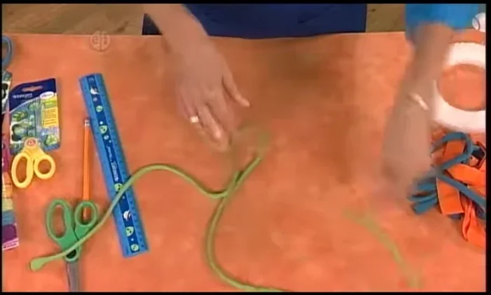 Open up the loops and pull the piece between your hands to curl the strips.
