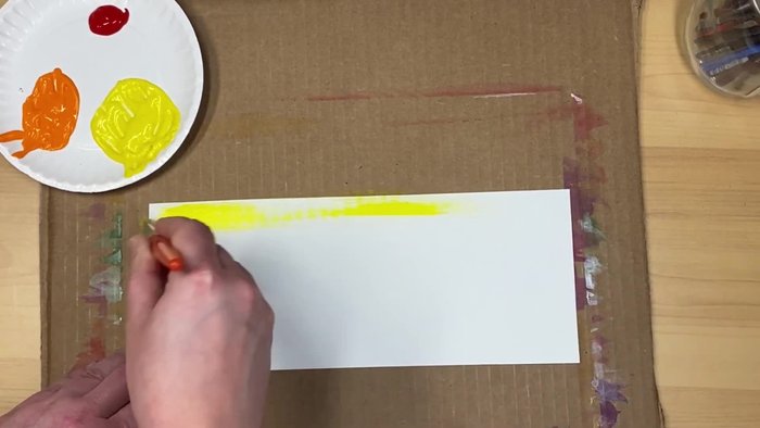 Start with the lightest color (e.g., yellow) at the top of your paper. Apply enough paint to cover the area, spreading it until you run out of paint on your brush. This should be about halfway down the paper.
