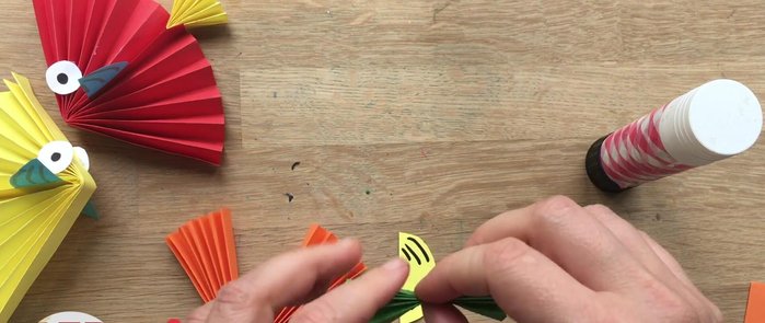 Assemble the fish: Fold both the body and tail in half. Apply glue to the inside of the tail fin and the edges of the body fan. Attach the tail fin and body sections together.