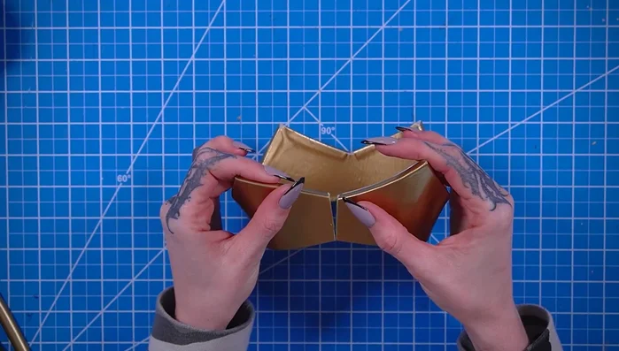 Cover an EVA foam half dowel with gold fabric and glue it to the bottom edge of the crown.