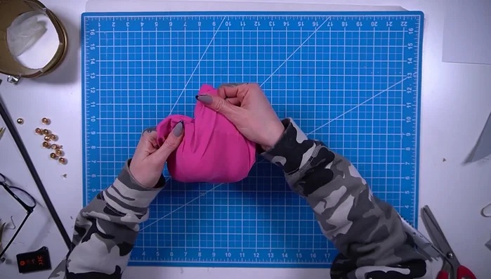 Trim, fold, and glue the edges of the pink fabric.