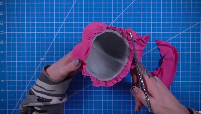 Trim, fold, and glue the edges of the pink fabric.