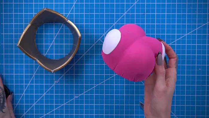 Add white fabric circles and a gold button to the cushion.