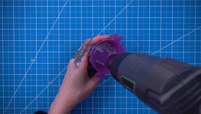 Sculpt and attach small eyes using DecoArt thermoplastic beads, a heat gun, and black paint.