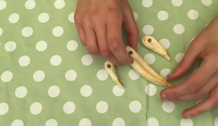 String the necklace: Thread the painted pieces onto string, using double knots to secure each piece. Ensure the pieces face forward and are spaced evenly.