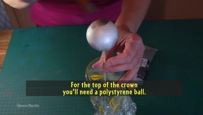 Prepare the polystyrene ball for the crown top by covering it with acrylic paint or PVA glue with paint.