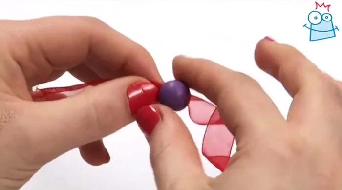 Thread a round purple bead onto each side of the ribbon.