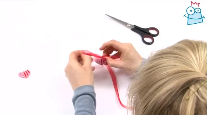 Thread the last heart onto the other end of the ribbon.