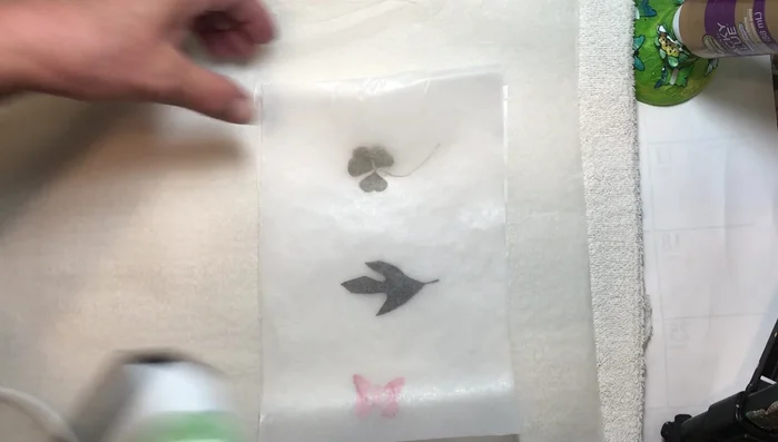 Iron the wax paper sandwich on medium heat. Move the iron slowly, ensuring the wax melts and seals the leaves between the paper.