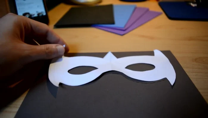 Cut out the paper template. Draw half the design, fold the paper, and cut to ensure symmetry.