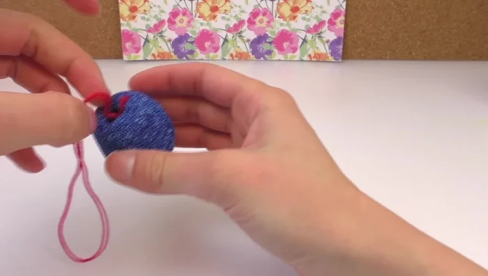 Insert the knotted string through the hole and secure it with more foam clay.