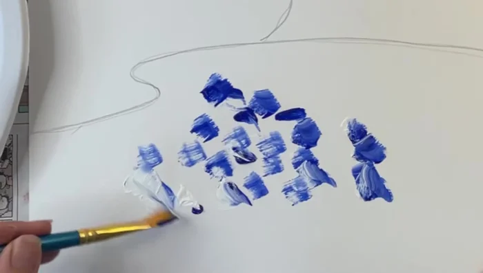 Paint the pond: Mix blue and white on the brush, then apply rough dabs inside the pond outline. Add red and yellow on top of the wet blue/white, allowing colors to mix naturally on the canvas.