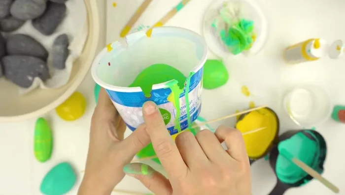 Create a paint-catching tray: Use a small container (like a yogurt cup), punch holes for skewers, and cut the slots.