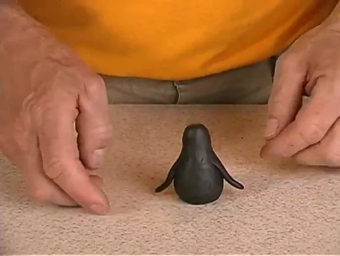 Make a tail by rolling a small ball of black clay into a pointed cone shape and attaching it to the body.