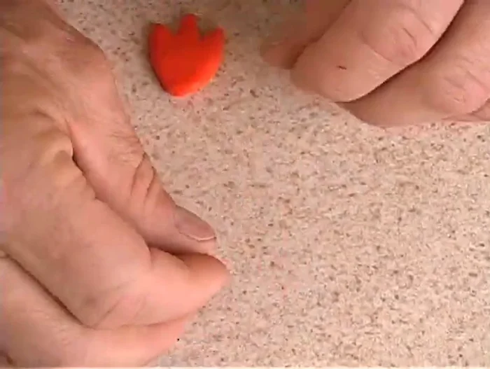 Make the beak by rolling a small piece of orange clay into a cone shape and attaching it to the body using a toothpick.