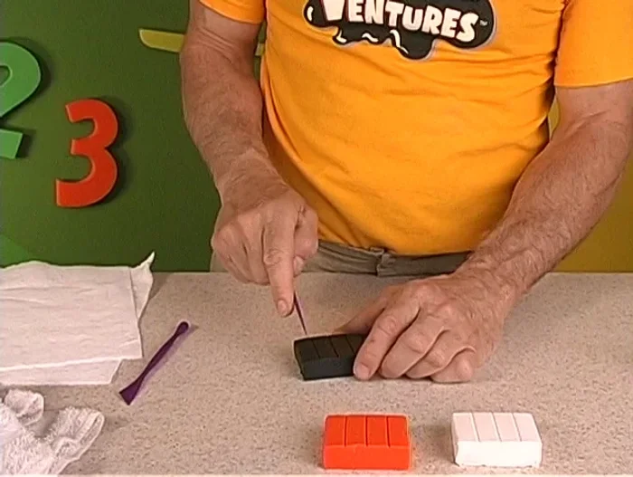 Make the penguin's pear-shaped body using black clay.