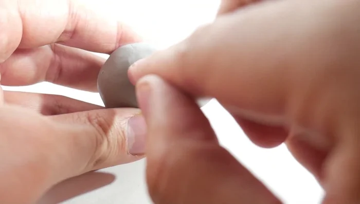 Create the mouth: Use a cutter to make a mouth line, then use a toothpick or pointed tool to create small holes at the corners for expression.