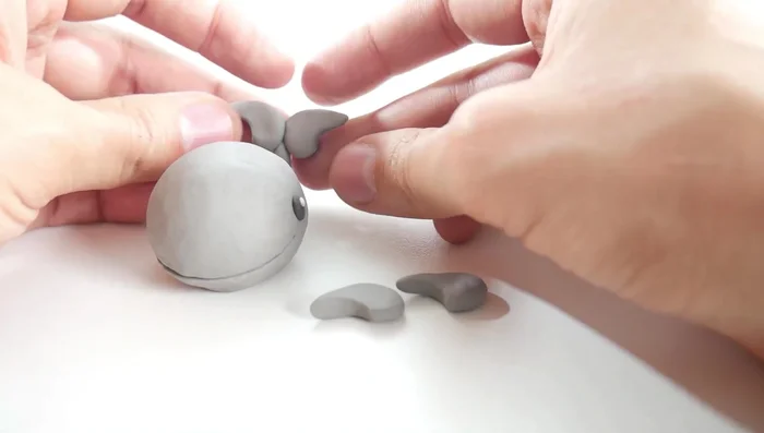 Attach the fins: Attach two comma-shaped pieces to the back for the tail fins, and two to the sides for the side fins.