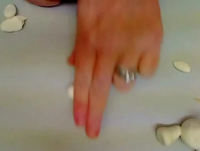 Create the arms: Roll small balls of white clay, roll them into slightly pointed shapes, and attach them to the body.