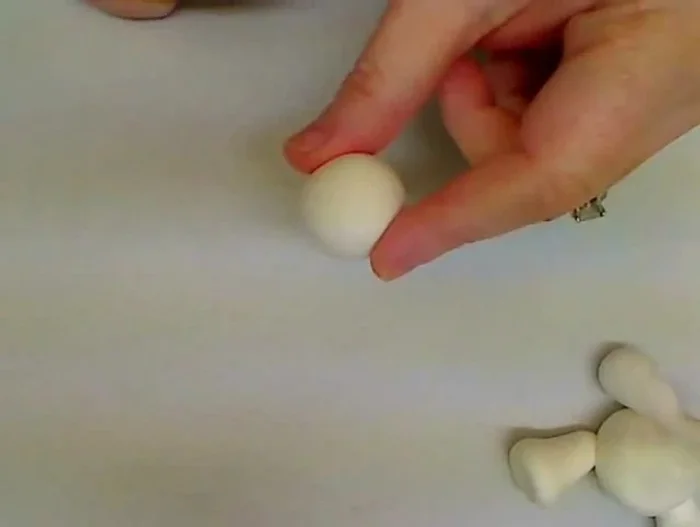 Shape the head: Roll a 1-inch ball of white clay. Use a toothpick to hollow out the area where the head will attach to the neck.