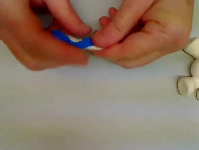 Make the candy cane: Twist together logs of red and white clay to create a candy cane stripe effect, then shape it and place it in the bear's lap.