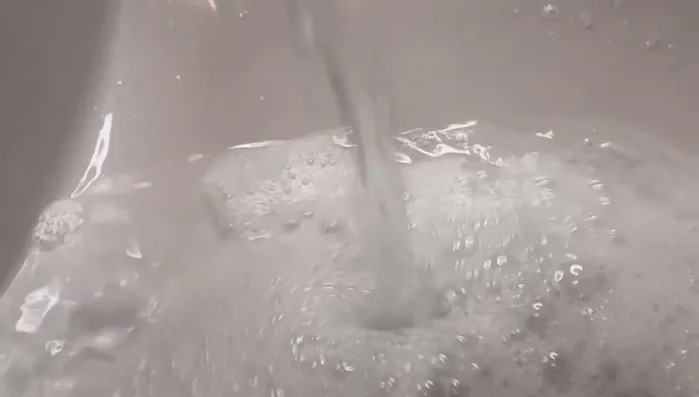 Wash the rock with warm soapy water, let it dry, and apply two base coats of white acrylic paint for vibrant colors.