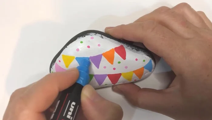 Add colorful polka dots randomly around the rock for a playful touch.