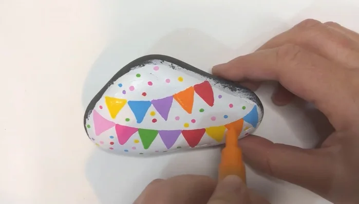 Outline the string lines, triangles, and letters with a fine black paint pen.