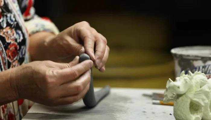 Shape the head, blending and smoothing the clay. Create the snout, nostrils, and eyebrows.