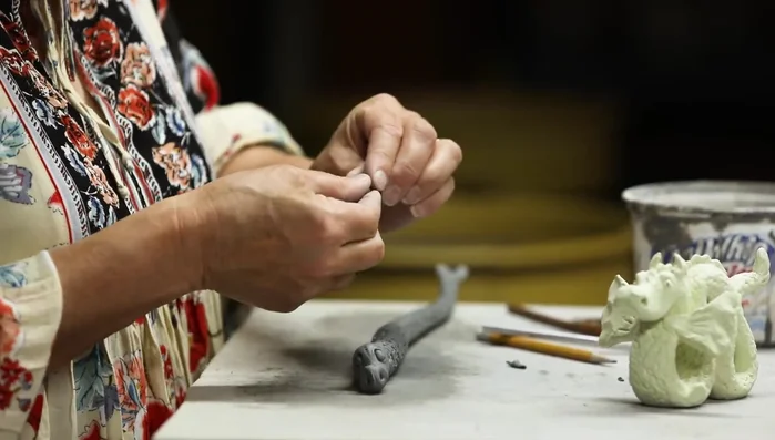 Add ears and horns by pinching and shaping small amounts of clay, scoring and slipping them into place.