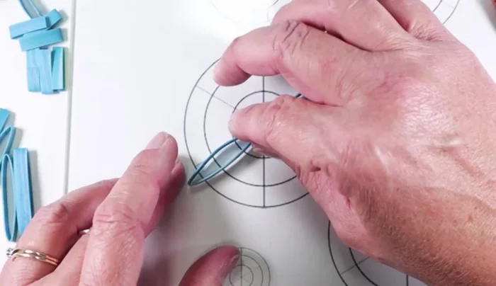 Assemble the snowflake using a template as a guide. Arrange six longer strips evenly around the center, gluing with super glue.