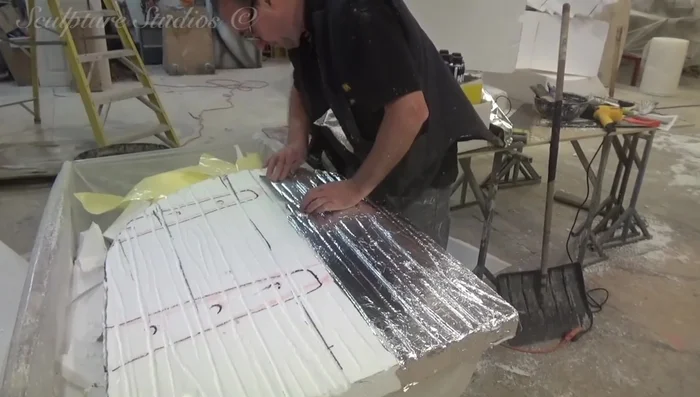 Applying a protective layer of sticky back tin foil to the polystyrene.