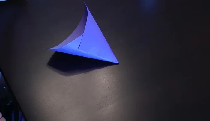 Cut off the top of the cone, ensuring it fits the top of your bottle. Measure to ensure it's the right size before cutting.