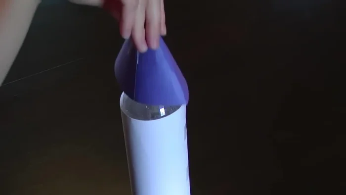 Place the cone on top of the bottle and tape it securely.