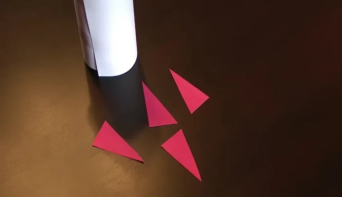Cut out red triangles for the rocket fins and tape them onto the bottle.