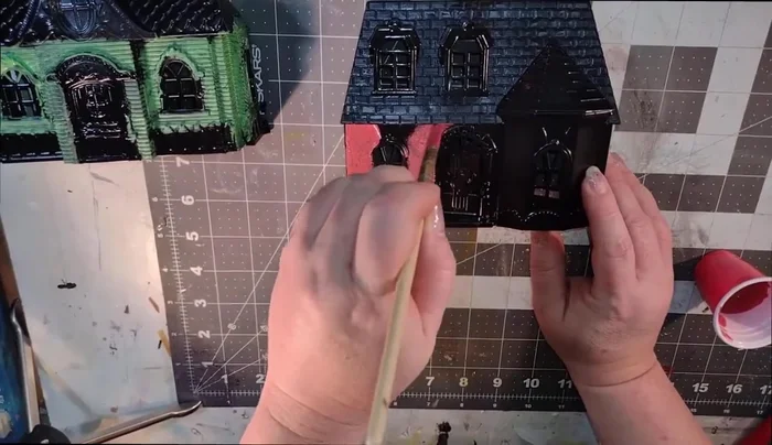 Apply a thin coat of red paint to the second dollhouse.