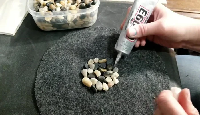 Continue applying glue and adding rocks in sections until the entire felt is covered. Work quickly as the glue dries fast.