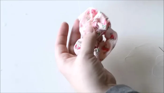 Attach the flower: Wrap the gathered flower fabric into a spiral and sew to secure. Hand-sew the flower onto the purse. Add a bead or gem to the center using hot glue (optional).