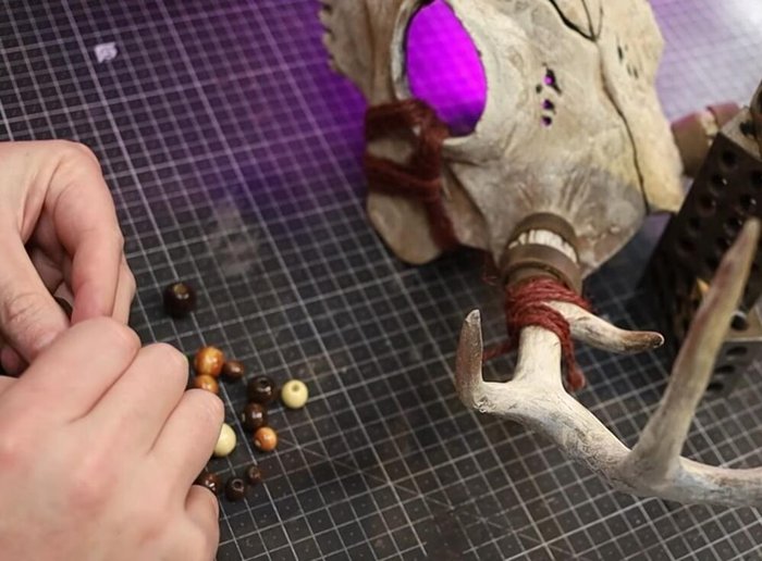 Add leather strips and wooden beads to the jute wrapping.