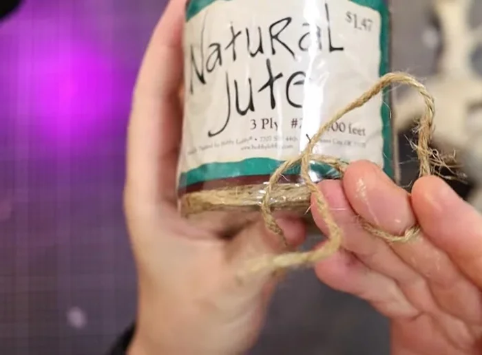 Add leather strips and wooden beads to the jute wrapping.