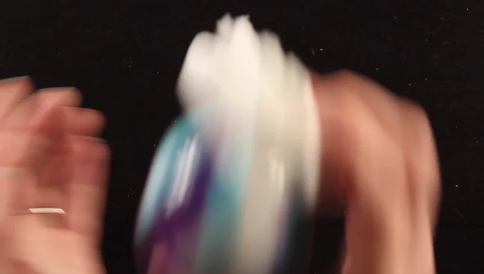 Place a paper towel over the opening of the ornament, hold it tightly, and shake vigorously, turning the ornament in different directions to marble the paint.