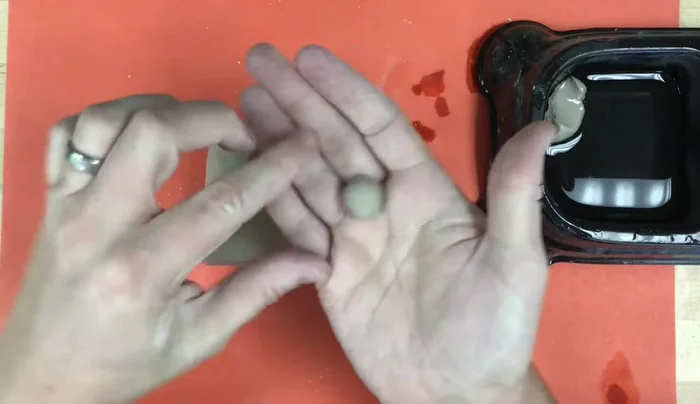 Add the beak: Roll a small ball of clay, flatten one side, and pinch the other to a point. Attach it to the penguin's head using slip (wet clay), scratching both surfaces before joining.