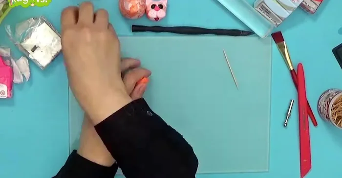 Attach paws and tail: Attach the paws to the body. Combine orange and pink clay for the tail, roll it into a snake-like shape, and attach it to the body using a toothpick.