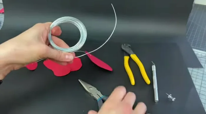 Create connection rings. Cut a piece of wire (around 4 inches), use the exacto knife to create a tight coil leaving an inch overhang, then twist and crimp to secure.